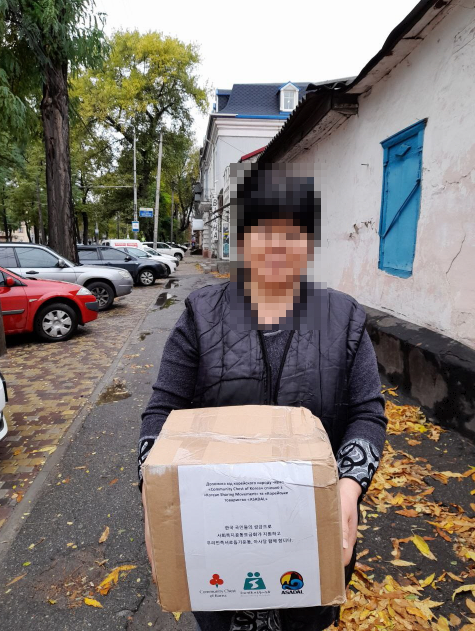 우리민족의 긴급 생필품 박스를 받은 고려인 동포(사진=우리민족서로돕기운동)
