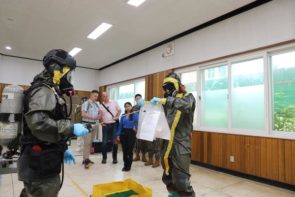 화생방특수임무단 장병들이 슬롯사이트(OPCW) 대표단 앞에서 대화생방테러작전수행절차 중 표본을 인계하기 위한 물품 제독 절차를 보여주고 있다. (사진=국방부 제공)