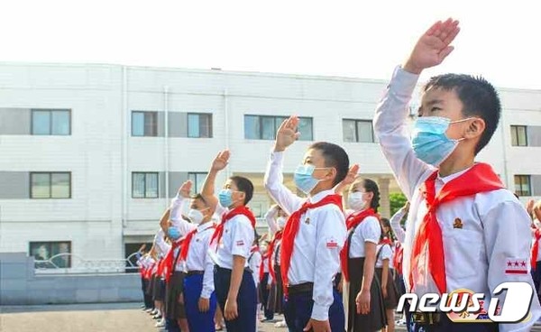 '인공기'에 경례하는 북한 어린이들(사진=노동신문/뉴스1)