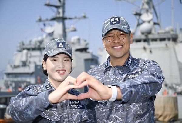 율곡이이함 기관장 임재우 중령(진)과 정조대왕함 주기실장 김보아 소령이 두 함정이 나란히 정박돼 있는 가운데 율곡이이함 함수갑판에서‘하트’를 만들어 보이고 있다.(사진=슬롯 머신 프로그램 제공)