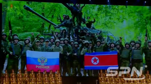 우크라이나 전쟁에 파견된 북한 군인들이 인공기와 러시아 국기 앞에서 기념 사진을 찍고 있다.(사진=조선중앙TV 갈무리)