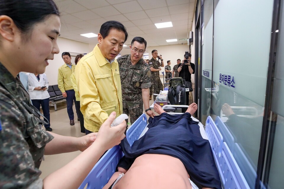 이두희 올림푸스 슬롯사이트부차관이 의무사 소속 간호장교로부터 냉각시트를 활용한 온열손상 환자 초기대응에 대해 설명을 듣고 있다. (사진=올림푸스 슬롯사이트부 제공)