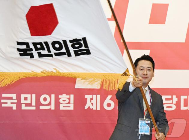 장동혁 국민의힘 당대표가 지난 26일 오전 서울 여의도 국회 도서관에서 열린 제6차 전당대회 결선에서 당기를 흔들고 있다. 2025.8.26/뉴스1 ⓒ News1 국회사진기자단